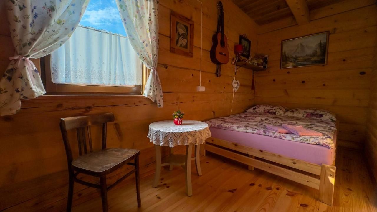 Pokój z łóżkiem, krzesłem i stolikiem z koronkową serwetą przy oknie