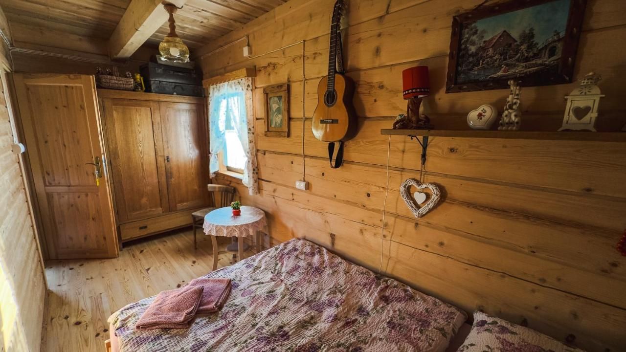 Sypialnia z gitarą na ścianie, szafą i okrągłym stolikiem